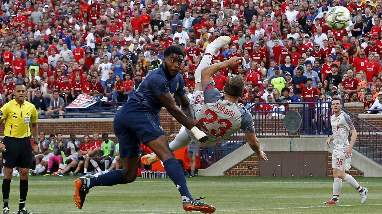 TOPSHOT - Liverpool FC Sheridan Shaqiri (R) shoots and scores during the second half of the 2018 International Champions Cup football match against Manchester United at Michigan Stadium in Ann Arbor, Michigan on July 28, 2018. - Liverpool FC beat Manchester United 4-1 in their friendly.