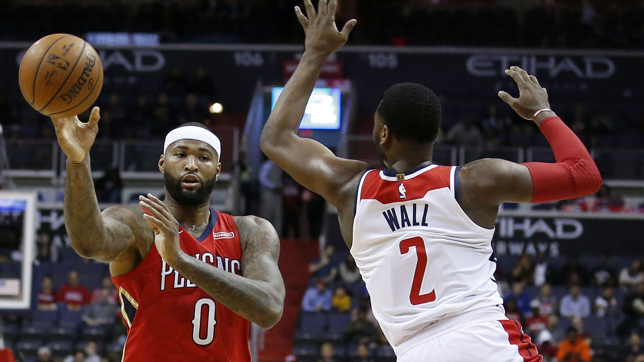 WASHINGTON, DC - DECEMBER 19: DeMarcus Cousins #0 of the New Orleans Pelicans passes the ball around John Wall #2 of the Washington Wizards in the first half at Capital One Arena on December 19, 2017 in Washington, DC.