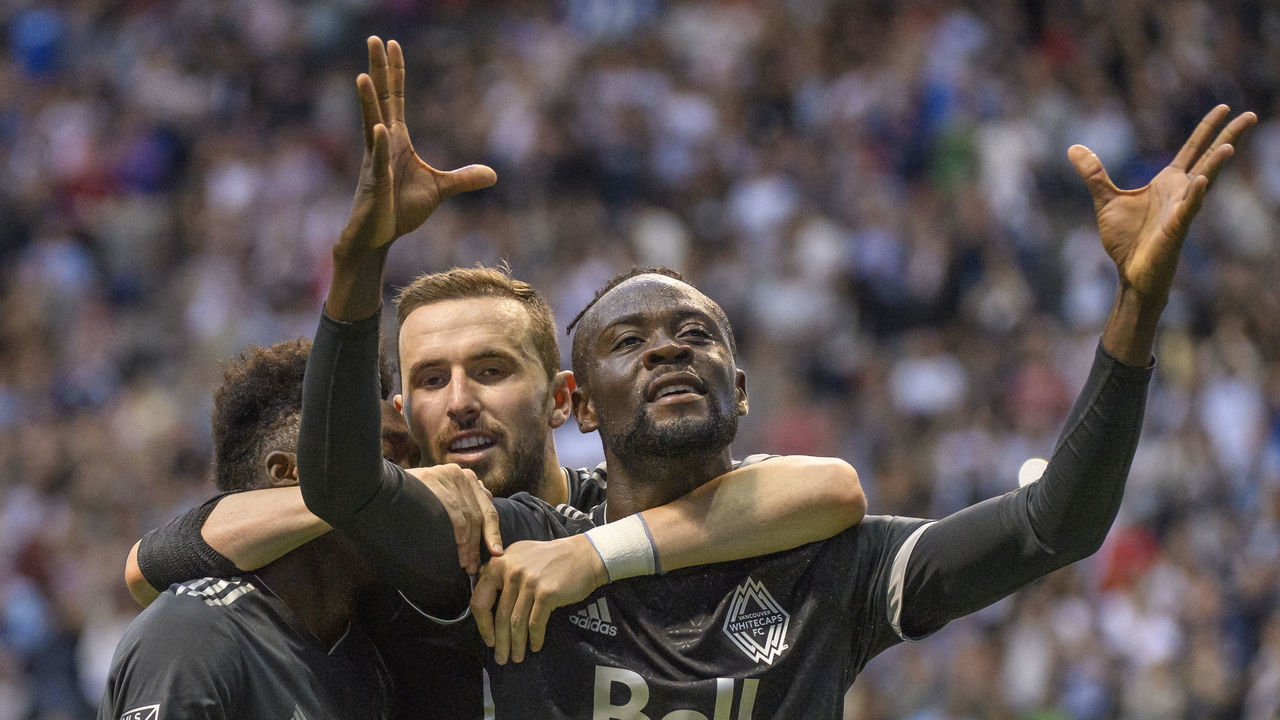 VANCOUVER, BC - JULY 07: Alphonso Davies #67 of the Vancouver Whitecaps FC (left), Jordon Mutch #77 of the Vancouver Whitecaps FC and Kei Kamara #23 of the Vancouver Whitecaps FC celebrate Kamara's goal against the the Chicago Fire at BC Place on July 7, 2018 in Vancouver, Canada.