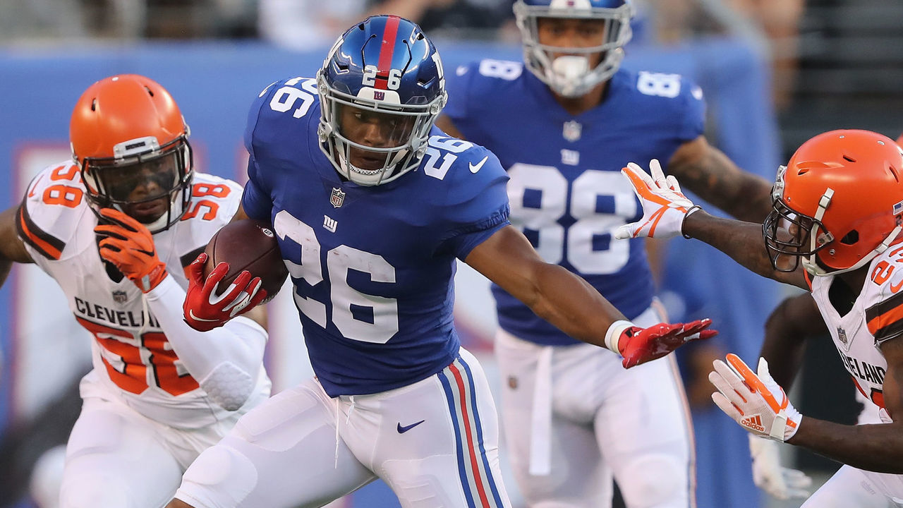EAST RUTHERFORD, NJ - AUGUST 09: Saquon Barkley #26 of the New York Giants carries the ball as Damarious Randall #23 of the Cleveland Browns defends in the first quarter during their preseason game on August 9,2018 at MetLife Stadium in East Rutherford, New Jersey.