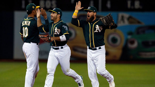 OAKLAND, CA - AUGUST 04: Marcus Semien #10 of the Oakland Athletics, Ramon Laureano #22 and Nick Martini #38 celebrate after the game against the Detroit Tigers at the Oakland Coliseum on August 4, 2018 in Oakland, California. The Oakland Athletics defeated the Detroit Tigers 2-1.
