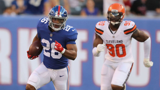 EAST RUTHERFORD, NJ - AUGUST 09: Saquon Barkley #26 of the New York Giants carries the ball as Emmanuel Ogbah #90 of the Cleveland Browns in the first quarter during their preseason game on August 9,2018 at MetLife Stadium in East Rutherford, New Jersey.