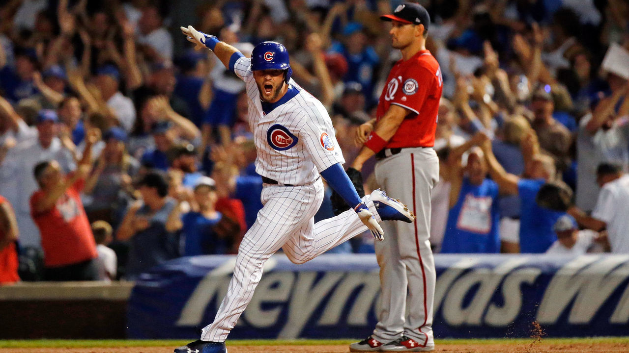 CHICAGO, IL - AUGUST 12: David Bote #13 of the Chicago Cubs celebrates his walk-off grand slam as Ryan Zimmerman #11 of the Washington Nationals looks on at Wrigley Field on August 12, 2018 in Chicago, Illinois. The Chicago Cubs won 4-3.