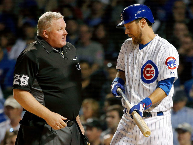 CHICAGO, IL - APRIL 18: Ben Zobrist #18 of the Chicago Cubs talks with home plate umpire Bill Miller #26 after striking out to end the third inning at Wrigley Field on April 18, 2017 in Chicago, Illinois.