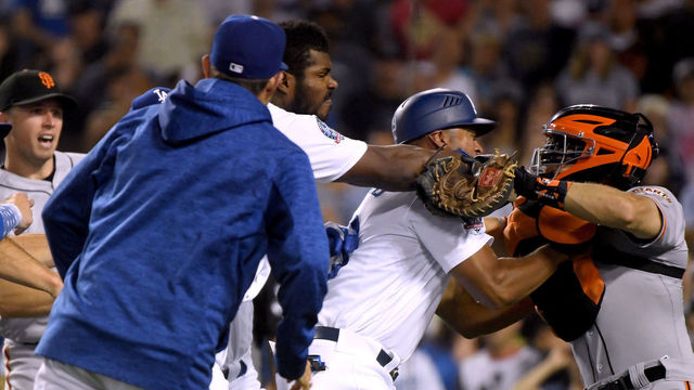 LOS ANGELES, CA - AUGUST 14: Yasiel Puig #66 of the Los Angeles Dodgers and Nick Hundley #5 of the San Francisco Giants fight as first base coach George Lombard #29 comes between the two during the seventh inning at Dodger Stadium on August 14, 2018 in Los Angeles, California. Both players would be ejected from the game.