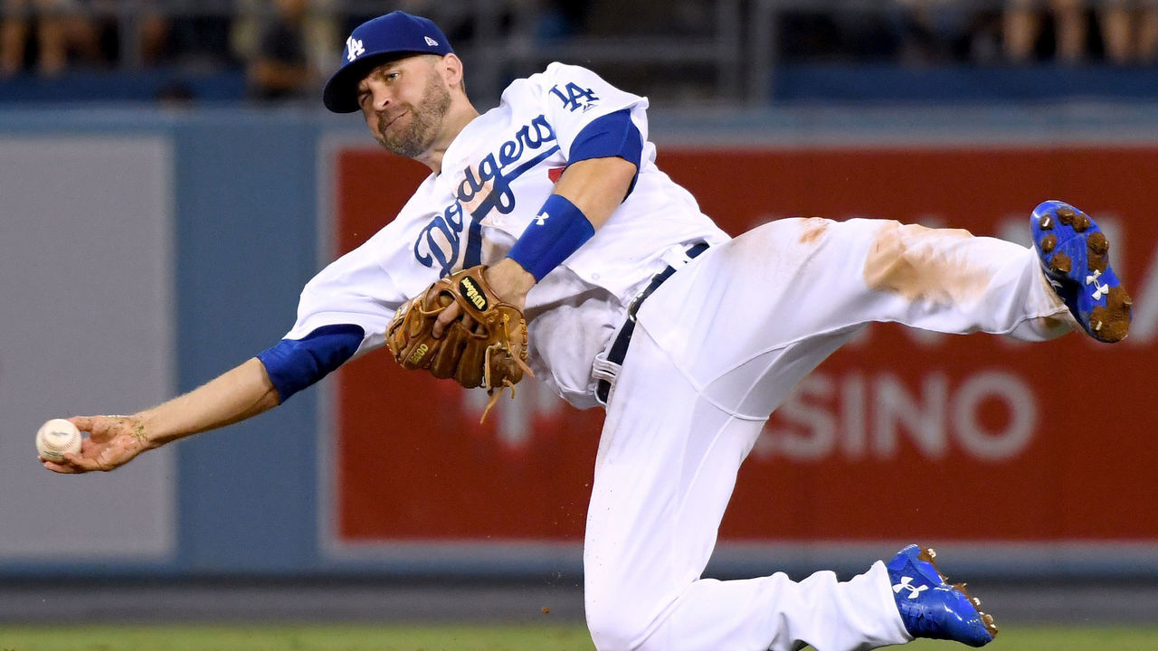 LOS ANGELES, CA - AUGUST 13: Brian Dozier #6 of the Los Angeles Dodgers makes an off balance throw to first as Steven Duggar #6 of the San Francisco Giants is safe at first during the third inning at Dodger Stadium on August 13, 2018 in Los Angeles, California.
