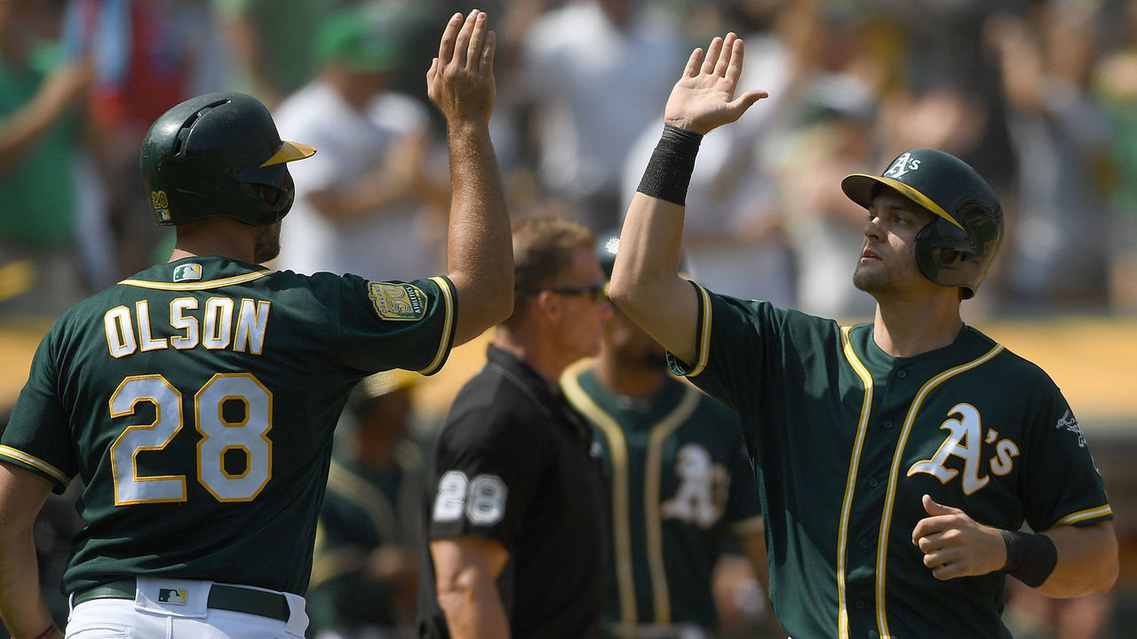 OAKLAND, CA - AUGUST 18: Matt Olson #28 and Chad Pinder #18 of the Oakland Athletics celebrates after they both scored against the Houston Astros in the bottom of the eighth inning at Oakland Alameda Coliseum on August 18, 2018 in Oakland, California.
