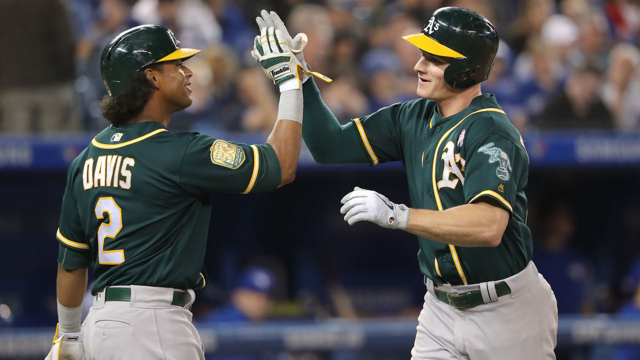 TORONTO, ON - MAY 17: Matt Chapman #26 of the Oakland Athletics is congratulated by Khris Davis #2 after hitting a two-run home run in the sixth inning during MLB game action against the Toronto Blue Jays at Rogers Centre on May 17, 2018 in Toronto, Canada.