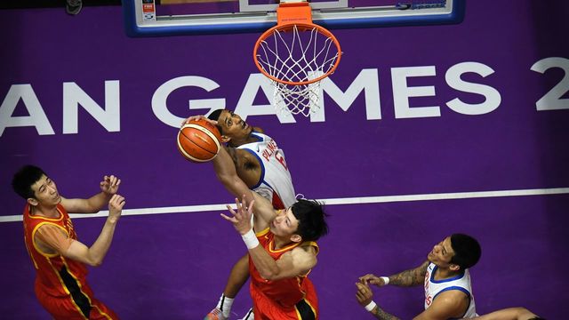 China's Zhou Qi (bottom C) blocks a shot by the Philippines' Jordan Clarkson (top C) in their men's basketball preliminary Group D game between China and the Philippines during the 2018 Asian Games in Jakarta on August 21, 2018.