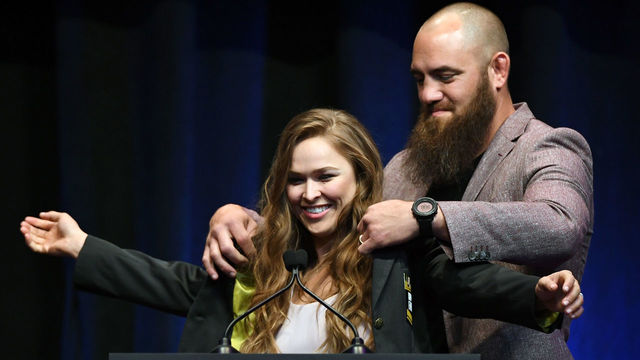 LAS VEGAS, NV - JULY 05: Mixed martial artist Travis Browne (R) puts a UFC Hall of Fame jacket on his wife Ronda Rousey after she became the first female inducted into the UFC Hall of Fame at The Pearl concert theater at Palms Casino Resort on July 5, 2018 in Las Vegas, Nevada.