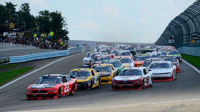 WATKINS GLEN, NY - AUGUST 04: Joey Logano, driver of the #22 Snap On Ford, and Brad Keselowski, driver of the #12 Wabash National Ford, lead the field into turn one following the start of the NASCAR Xfinity Series Zippo 200 at Watkins Glen International on August 4, 2018 in Watkins Glen, New York.