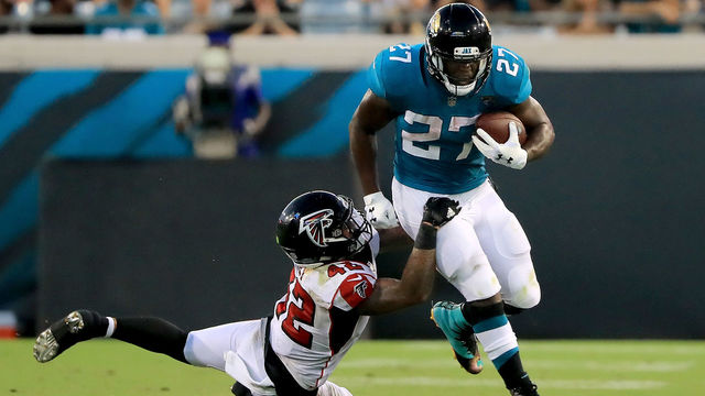 JACKSONVILLE, FL - AUGUST 25: Leonard Fournette #27 of the Jacksonville Jaguars runs past Emmanuel Ellerbee #52 of the Atlanta Falcons during a preseason game at TIAA Bank Field on August 25, 2018 in Jacksonville, Florida.