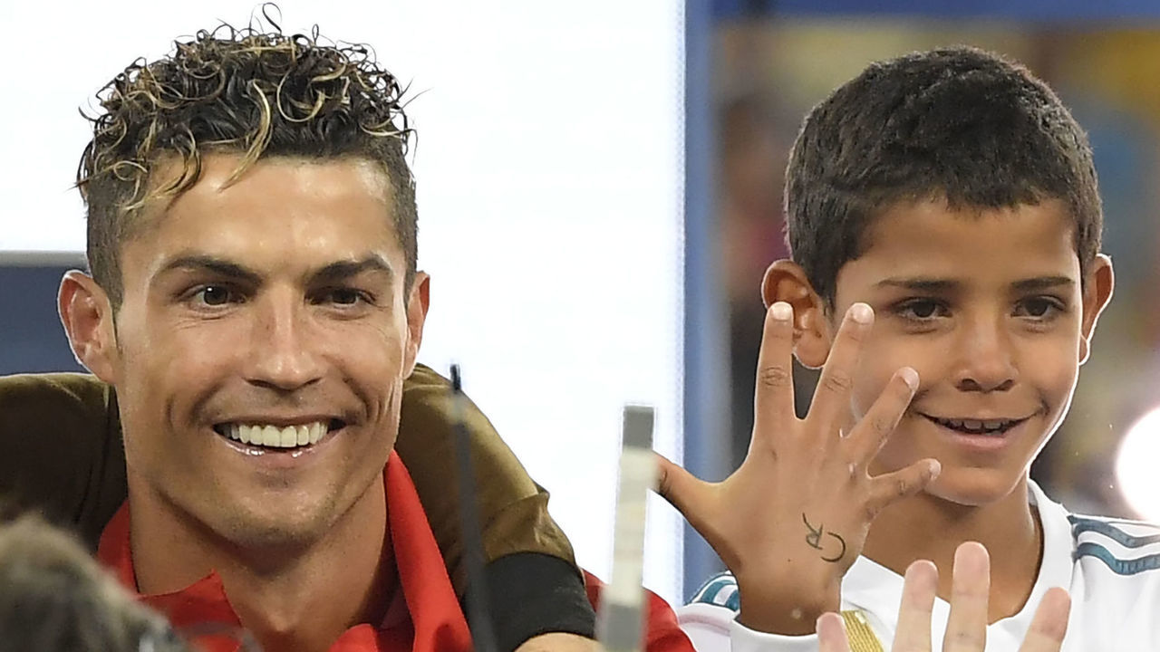 Real Madrid's Portuguese forward Cristiano Ronaldo celebrates with his son Cristiano junior after winning the UEFA Champions League final football match between Liverpool and Real Madrid at the Olympic Stadium in Kiev, Ukraine on May 26, 2018. - Real Madrid defeated Liverpool 3-1.