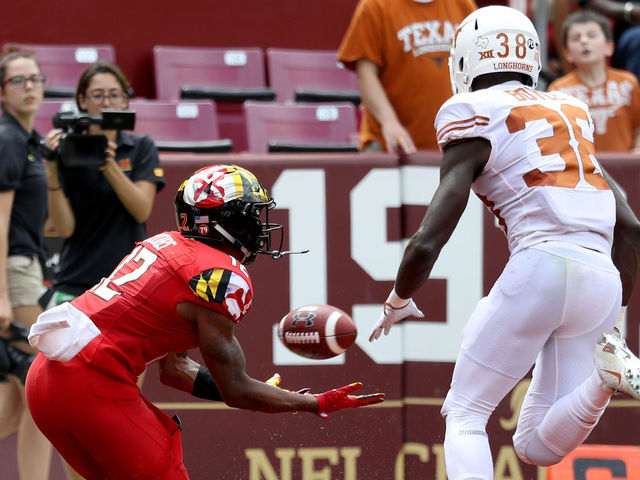 LANDOVER, MD - SEPTEMBER 1: Taivon Jacobs #12 of the Maryland Terrapins catches a first half touchdown pass in front of Kobe Boyce #38 of the Texas Longhorns at FedExField on September 1, 2018 in Landover, Maryland.
