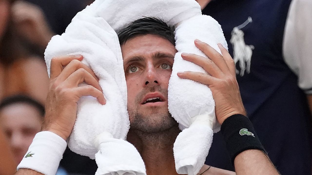 TOPSHOT - Novak Djokovic of Serbia cools off against Joao Sousa of Portugal during their 4th round 2018 US Open Men's Singles match at the USTA Billie Jean King National Tennis Center in New York on September 3, 2018.
