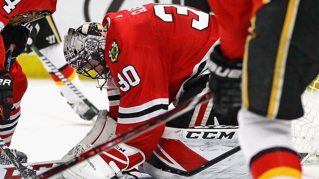 CHICAGO, IL - FEBRUARY 06: Jeff Glass #30 of the Chicago Blackhawks covers the puck on a save against the Calgary Flames at the United Center on February 6 2018 in Chicago, Illinois.