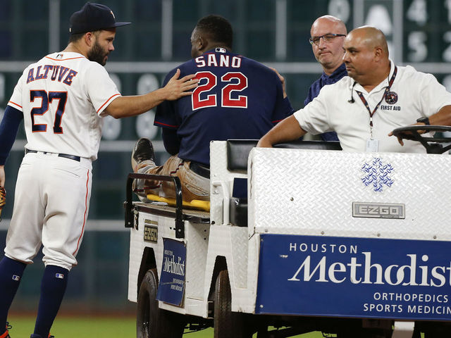 HOUSTON, TX - SEPTEMBER 04: Jose Altuve #27 of the Houston Astros gives Miguel Sano #22 of the Minnesota Twins a pat onk the back as he carted off in the second inning after sustaining an injury sliding into second base at Minute Maid Park on September 4, 2018 in Houston, Texas.
