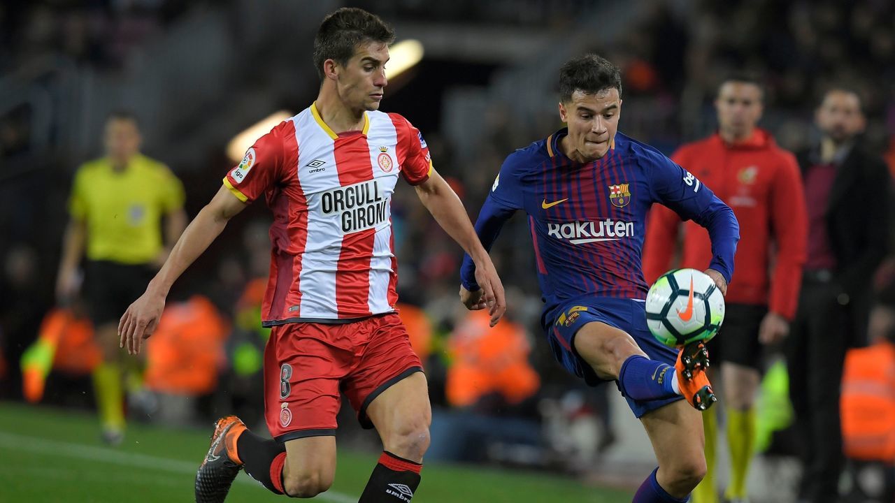 Girona's Spanish midfielder Pere Pons (L) vies with Barcelona's Brazilian midfielder Philippe Coutinho during the Spanish league football match between FC Barcelona and Girona FC at the Camp Nou stadium in Barcelona on February 24, 2018. / AFP PHOTO / LLUIS GENE