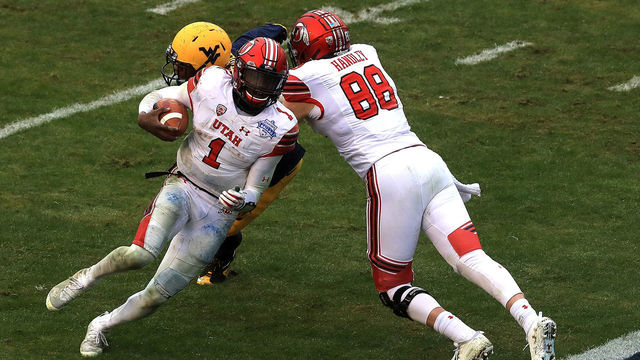 DALLAS, TX - DECEMBER 26: Tyler Huntley #1 of the Utah Utes runs for a touchdown while Harrison Handley #88 of the Utah Utes makes a block on Hakeem Bailey #24 of the West Virginia Mountaineers during Zaxby's Heart of Dallas Bowl on December 26, 2017 at Cotton Bowl in Dallas, Texas.