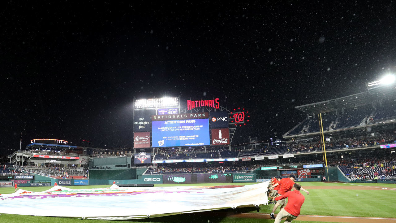 WASHINGTON, DC - SEPTEMBER 7: The grounds crew pulls the tarp onto the field during a rain delay of the Washington Nationals and Chicago Cubs game at Nationals Park on September 7, 2018 in Washington, DC.