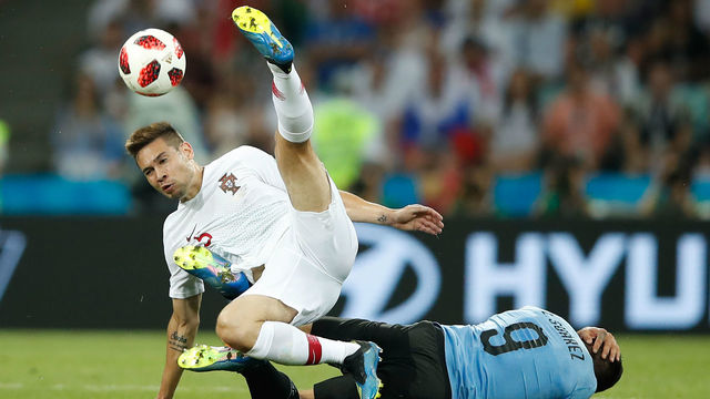 TOPSHOT - Portugal's defender Raphael Guerreiro (L) collides with Uruguay's forward Luis Suarez (R) during the Russia 2018 World Cup round of 16 football match between Uruguay and Portugal at the Fisht Stadium in Sochi on June 30, 2018.