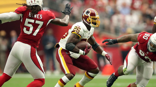 GLENDALE, AZ - SEPTEMBER 9: Running back Adrian Peterson #26 of the Washington Redskins runs past linebacker Josh Bynes #57 and defensive tackle Robert Nkemdiche #90 of the Arizona Cardinals during the first quarter at State Farm Stadium on September 9, 2018 in Glendale, Arizona.