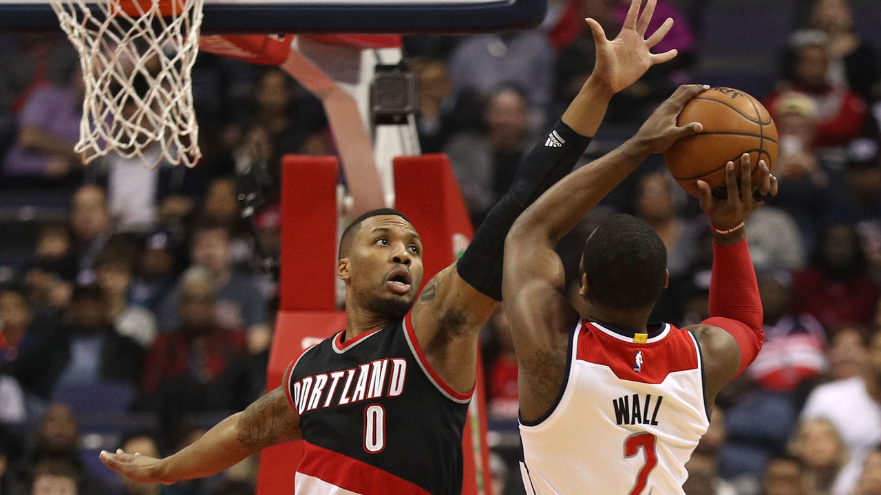 WASHINGTON, DC - JANUARY 16: John Wall #2 of the Washington Wizards tries to shoot in front of Damian Lillard #0 of the Portland Trail Blazers during the first half at Verizon Center on January 16, 2017 in Washington, DC.