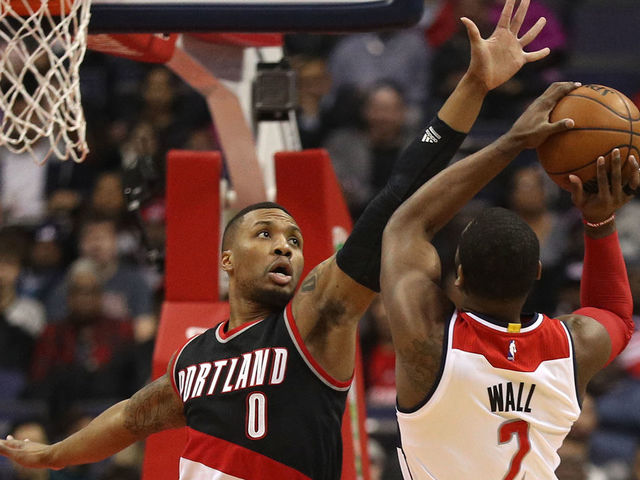 WASHINGTON, DC - JANUARY 16: John Wall #2 of the Washington Wizards tries to shoot in front of Damian Lillard #0 of the Portland Trail Blazers during the first half at Verizon Center on January 16, 2017 in Washington, DC.