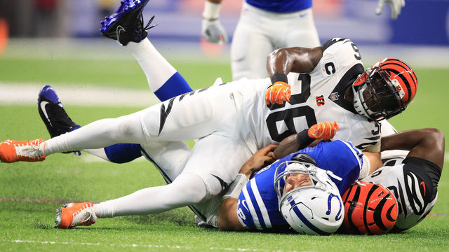 INDIANAPOLIS, IN - SEPTEMBER 09: Andrew Luck #12 of the Indianapolis Colts is taken down by Darius Phillips #38 and Michael Johnson #90 of the Cincinnati Bengals at Lucas Oil Stadium on September 9, 2018 in Indianapolis, Indiana.