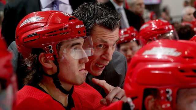 RALEIGH, NC - FEBRUARY 2: Assitant coach Rod Brind'Amour of the Carolina Hurricanes discusses game strategy with teammate Victor Rask #49 during an NHL game against the Detroit Red Wings on February 2, 2018 at PNC Arena in Raleigh, North Carolina.