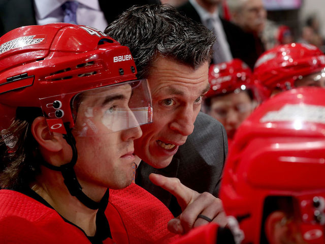 RALEIGH, NC - FEBRUARY 2: Assitant coach Rod Brind'Amour of the Carolina Hurricanes discusses game strategy with teammate Victor Rask #49 during an NHL game against the Detroit Red Wings on February 2, 2018 at PNC Arena in Raleigh, North Carolina.
