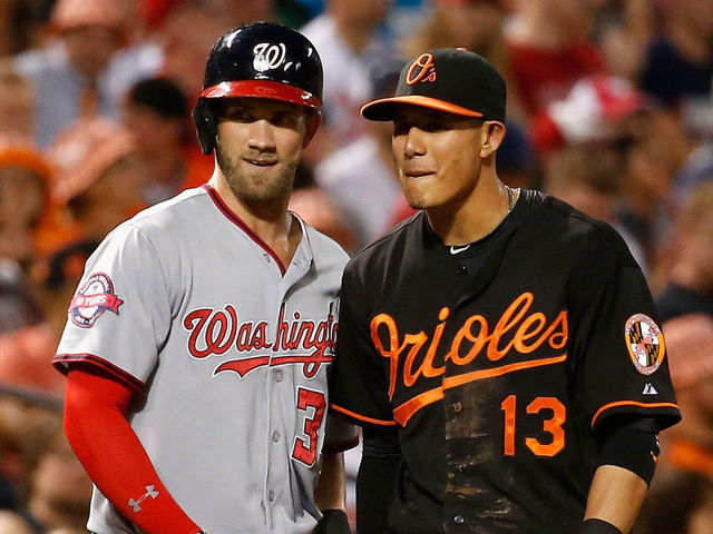 BALTIMORE, MD - JULY 10: Bryce Harper #34 of the Washington Nationals and Manny Machado #13 of the Baltimore Orioles talk during their game at Oriole Park at Camden Yards on July 10, 2015 in Baltimore, Maryland.