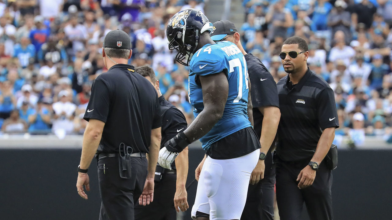 JACKSONVILLE, FL - SEPTEMBER 16: Cam Robinson #74 of the Jacksonville Jaguars is helped off the field by medical personal in the first half against the New England Patriots at TIAA Bank Field on September 16, 2018 in Jacksonville, Florida.
