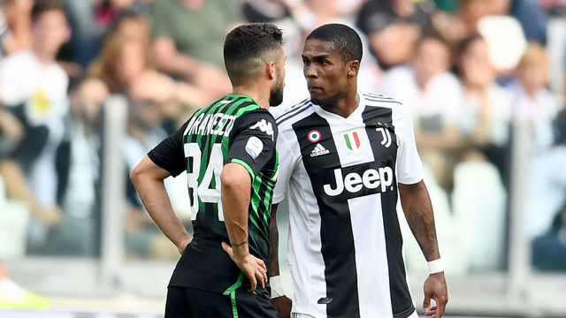 TURIN, ITALY - SEPTEMBER 16: Douglas Costa of Juventus (R) spits to Federico Di Francesco of Sassuolo during the serie A match between Juventus and US Sassuolo at Allianz Stadium on September 16, 2018 in Turin, Italy.
