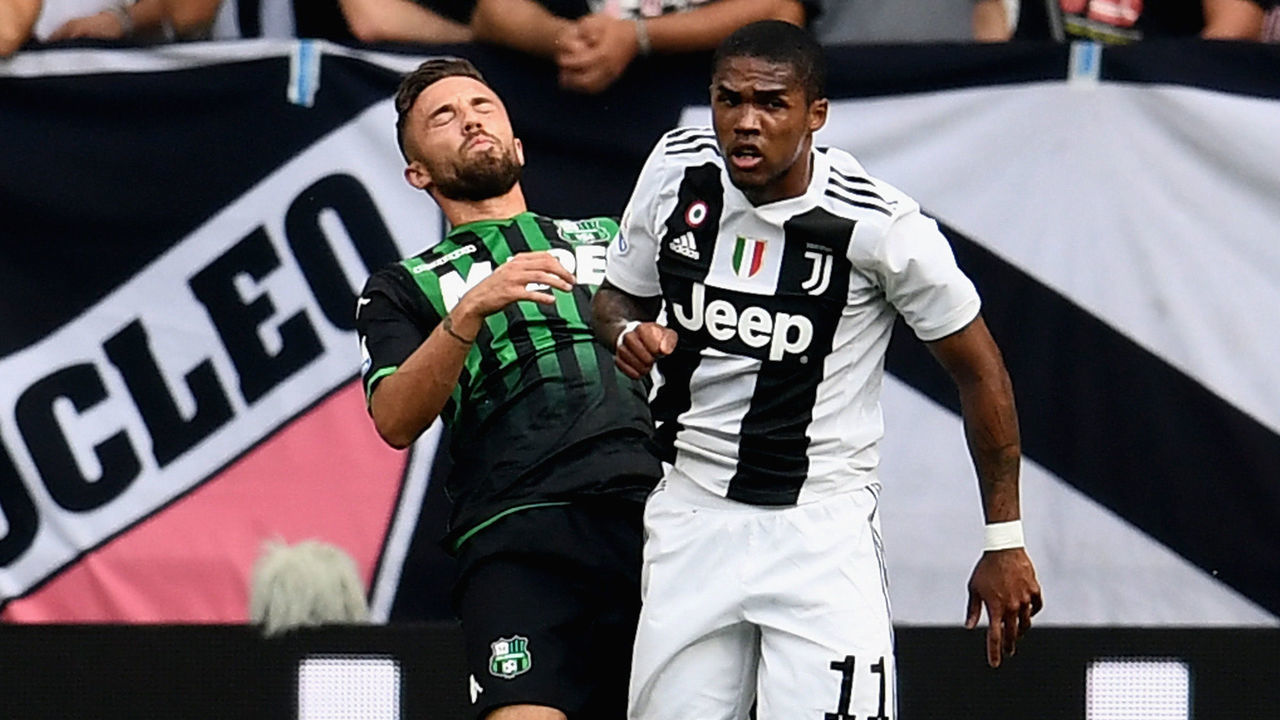 TURIN, ITALY - SEPTEMBER 16: Douglas Costa of Juventus (R) hits with an elbow Federico Di Francesco of Sassuolo during the serie A match between Juventus and US Sassuolo at Allianz Stadium on September 16, 2018 in Turin, Italy.