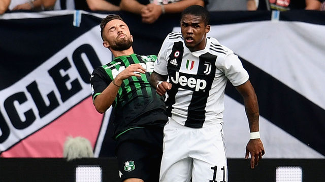 TURIN, ITALY - SEPTEMBER 16: Douglas Costa of Juventus (R) hits with an elbow Federico Di Francesco of Sassuolo during the serie A match between Juventus and US Sassuolo at Allianz Stadium on September 16, 2018 in Turin, Italy.