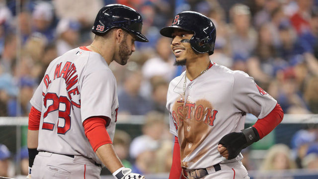 TORONTO, ON - MAY 12: Mookie Betts #50 of the Boston Red Sox is congratulated by J.D. Martinez #28 after scoring a run in the third inning during MLB game action against the Toronto Blue Jays at Rogers Centre on May 12, 2018 in Toronto, Canada.