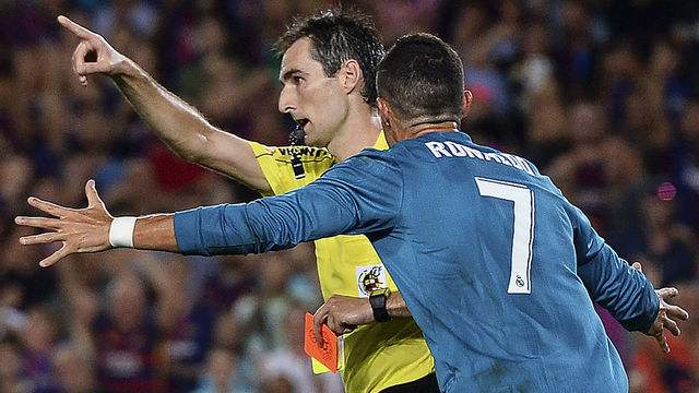 Real Madrid's Portuguese forward Cristiano Ronaldo (R) gestures after receiving a red card by referee Ricardo de Burgos Bengoetxea during the first leg of the Spanish Supercup football match between FC Barcelona and Real Madrid CF at the Camp Nou stadium in Barcelona on August 13, 2017. / AFP PHOTO / Josep LAGO