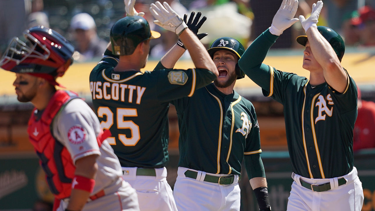 OAKLAND, CA - SEPTEMBER 20: Stephen Piscotty #25 of the Oakland Athletics is congratulated by Jed Lowrie #8 and Matt Chapman #26 after Piscotty hit a three-run home run against the Los Angeles Angels of Anaheim in the bottom of the third inning at Oakland Alameda Coliseum on September 20, 2018 in Oakland, California.