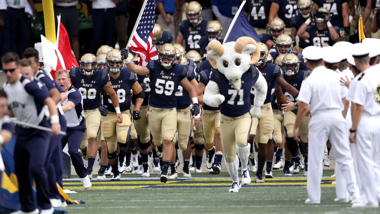 ANNAPOLIS, MD- SEPTEMBER 15: Travis Kerchner #59 of the Navy Midshipmen carries out the American flag before the start of Navy and Lehigh Mountain Hawks game at Navy-Marine Corps Memorial Stadium on September 15, 2018 in Annapolis, Maryland.