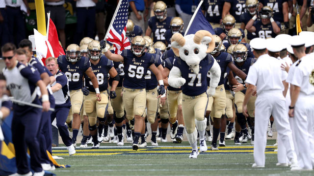 ANNAPOLIS, MD- SEPTEMBER 15: Travis Kerchner #59 of the Navy Midshipmen carries out the American flag before the start of Navy and Lehigh Mountain Hawks game at Navy-Marine Corps Memorial Stadium on September 15, 2018 in Annapolis, Maryland.