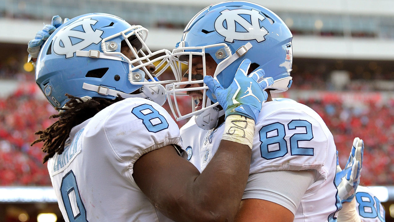RALEIGH, NC - NOVEMBER 25: Michael Carter #8 celebrates with Brandon Fritts #82 of the North Carolina Tar Heels after scoring a touchdown against the North Carolina State Wolfpack during their game at Carter Finley Stadium on November 25, 2017 in Raleigh, North Carolina.