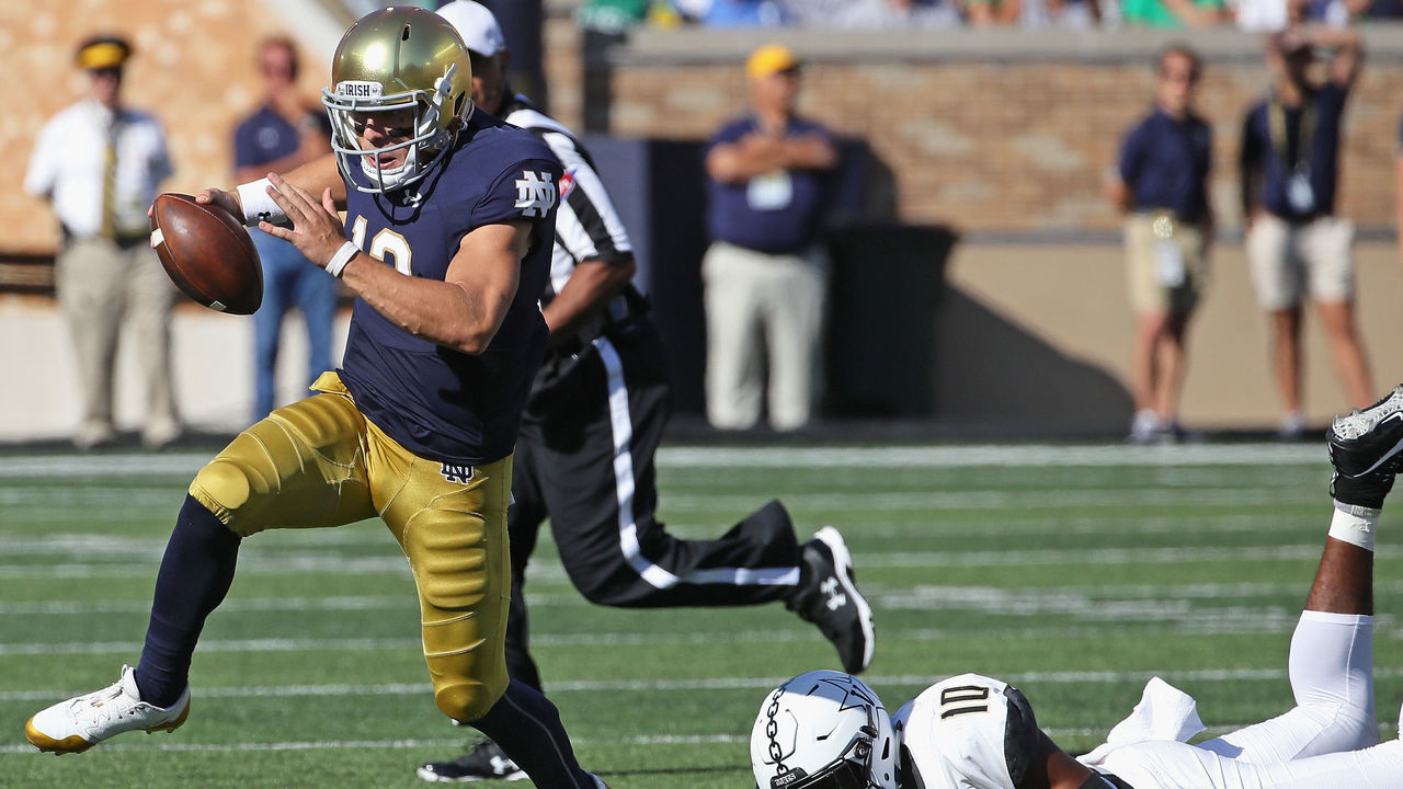 SOUTH BEND, IN - SEPTEMBER 15: Ian Book #12 of the Notre Dame Fighting Irish breaks away from Dayo Odeyingbo #10 of the Vanderbilt Commodores at Notre Dame Stadium on September 15, 2018 in South Bend, Indiana.