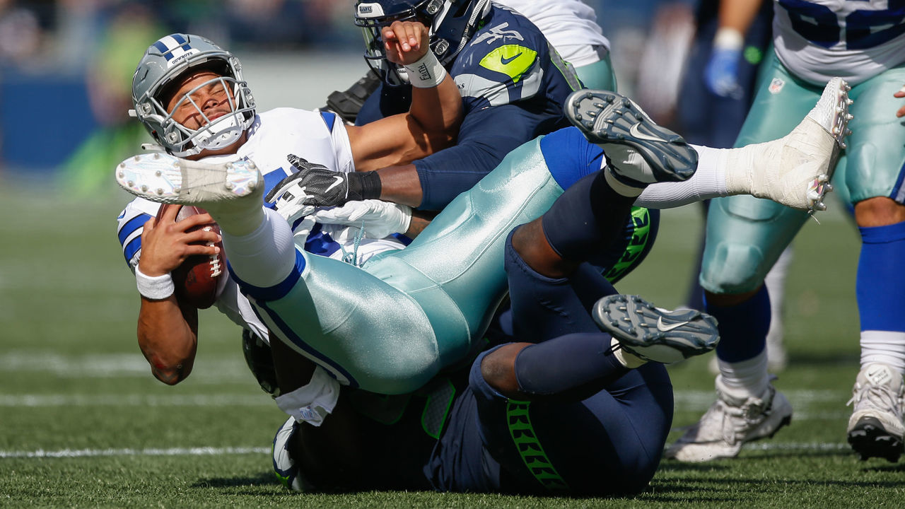 SEATTLE, WA - SEPTEMBER 23: Quarterback Dak Prescott #4 of the Dallas Cowboys is sacked by defensive end Dion Jordan #95 of the Seattle Seahawks at CenturyLink Field on September 23, 2018 in Seattle, Washington.