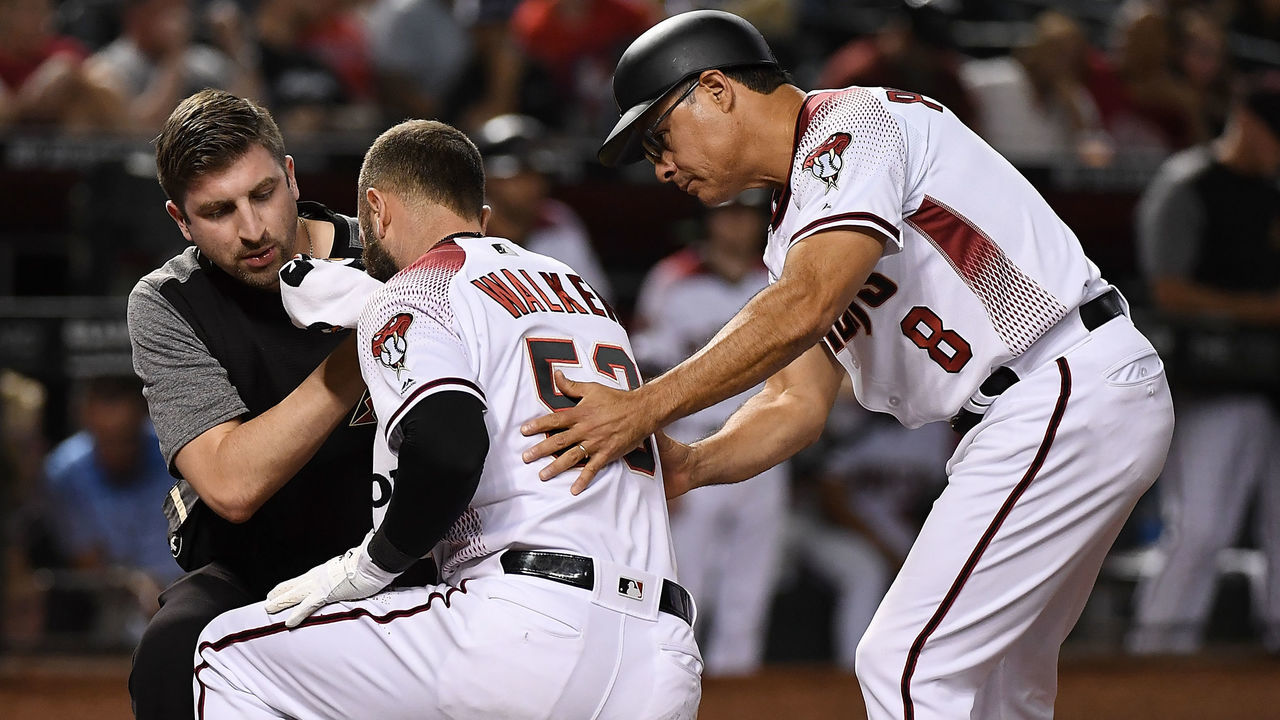 PHOENIX, AZ - SEPTEMBER 24: Head athletic trainer Ryan DiPanfilo and third base coach Tony Perezchica #8 of the Arizona Diamondbacks tend to Christian Walker #52 after being hit in the face by a pitch by Kenta Maeda #18 of the Los Angeles Dodgers during the eighth inning at Chase Field on September 24, 2018 in Phoenix, Arizona.