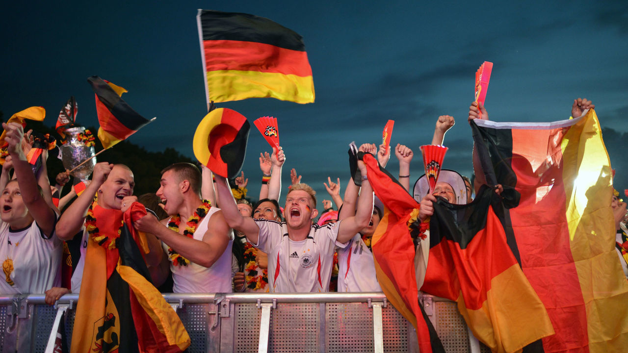 Fans of German national football team celebrate a goal scored by their team during a public viewing event in Berlin showing the EURO 2012 quarterfinal football match between Germany and Greece on June 22, 2012. The Euro 2012 football championship's quarterfinal match between Germany and Greece was played in Gdansk, Poland. AFP PHOTO / JOHANNES EISELE