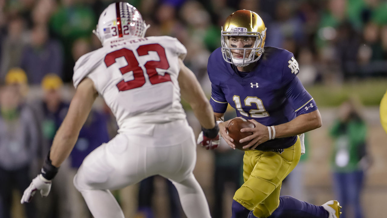 SOUTH BEND, IN - SEPTEMBER 29: Ian Book #12 of the Notre Dame Fighting Irish runs the ball as he is pursued by Joey Alfieri #32 of the Stanford Cardinal at Notre Dame Stadium on September 29, 2018 in South Bend, Indiana.