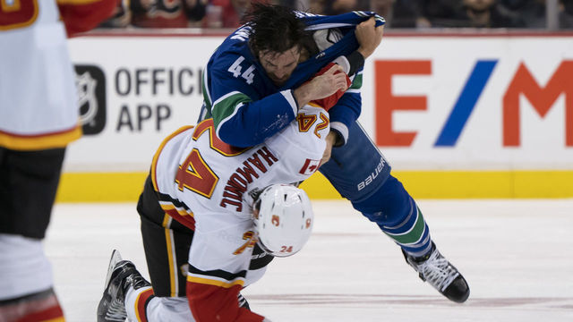 VANCOUVER, BC - OCTOBER 3: Erik Gudbranson #44 of the Vancouver Canucks knocks down Travis Hamonic #24 of the Calgary Flames during a fight in NHL action on October, 3, 2018 at Rogers Arena in Vancouver, British Columbia, Canada.