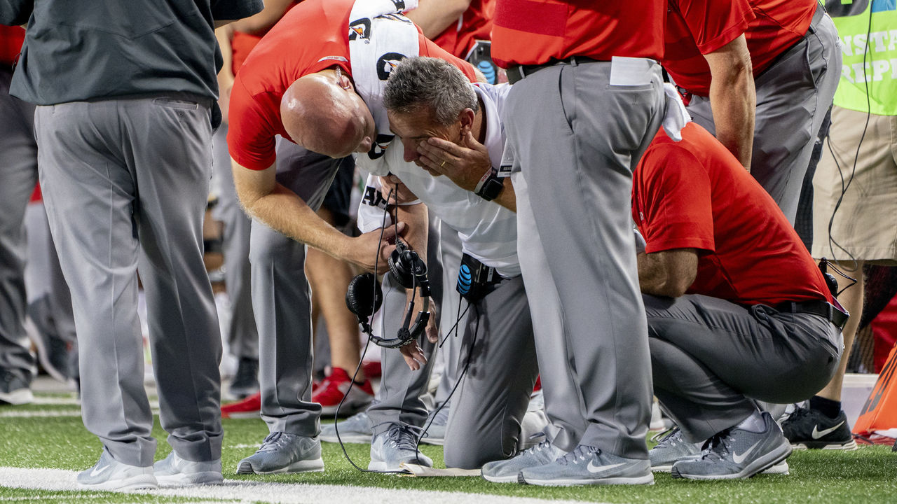COLUMBUS, OH - OCTOBER 06: Head coach Urban Meyer of the Ohio State Buckeyes holding his head after a collision on the sideline during the game between the Ohio State Buckeyes and the Indiana Hoosiers at Ohio Stadium on October 6, 2018 in Columbus, Ohio. Ohio State Buckeyes won 49-26.