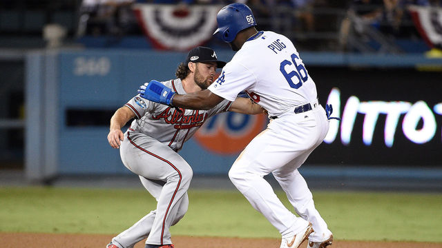LOS ANGELES, CA - OCTOBER 05: Yasiel Puig #66 of the Los Angeles Dodgers is caught stealing by Charlie Culberson #16 of the Atlanta Braves during the sixth inning during Game Two of the National League Division Series at Dodger Stadium on October 5, 2018 in Los Angeles, California.